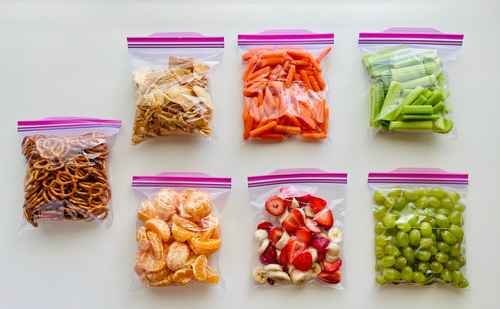 Resealable plastic food bags with portioned fruit, vegetables and snacks